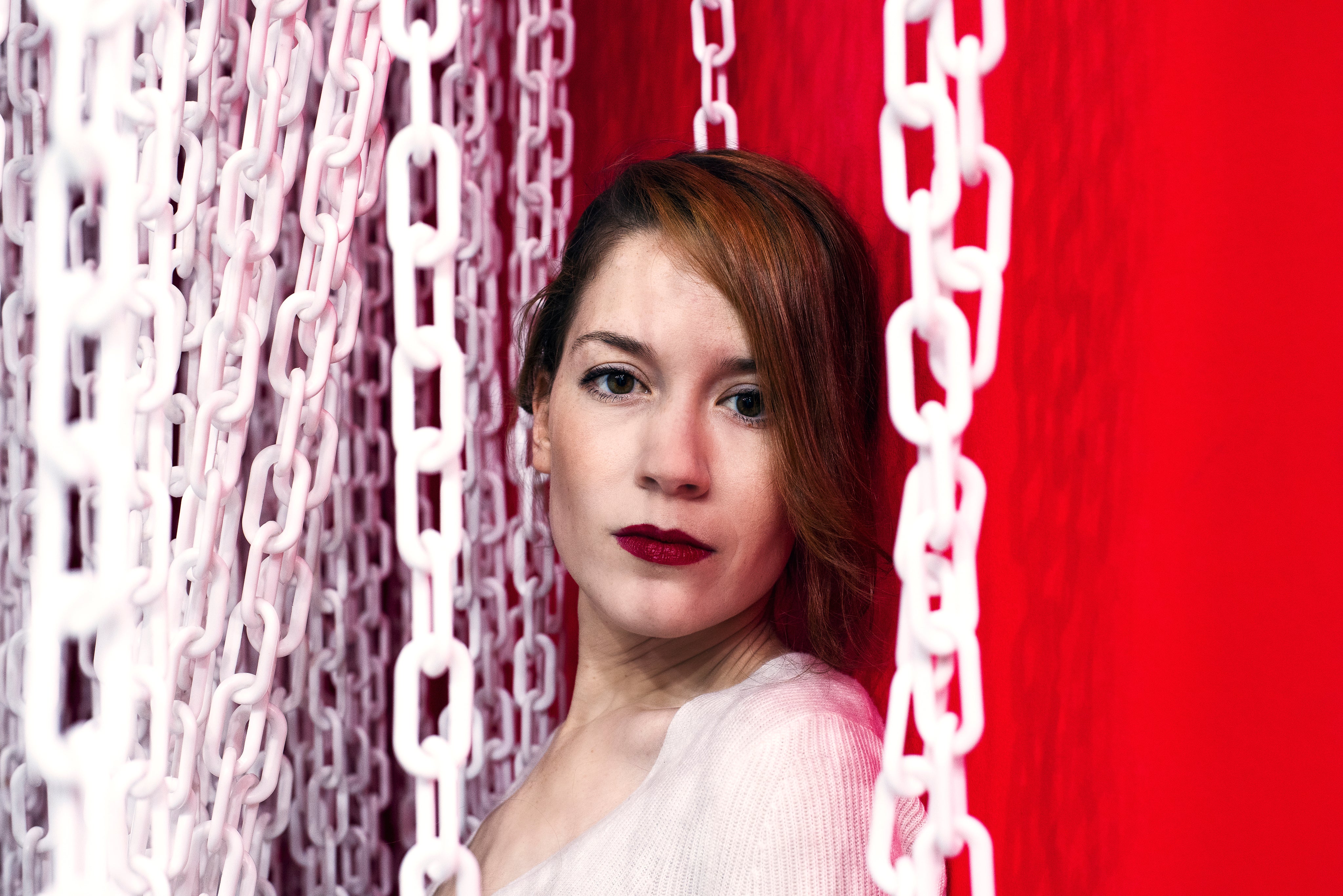 files/lady-in-red-against-a-red-wall-framed-by-white-chains.jpg